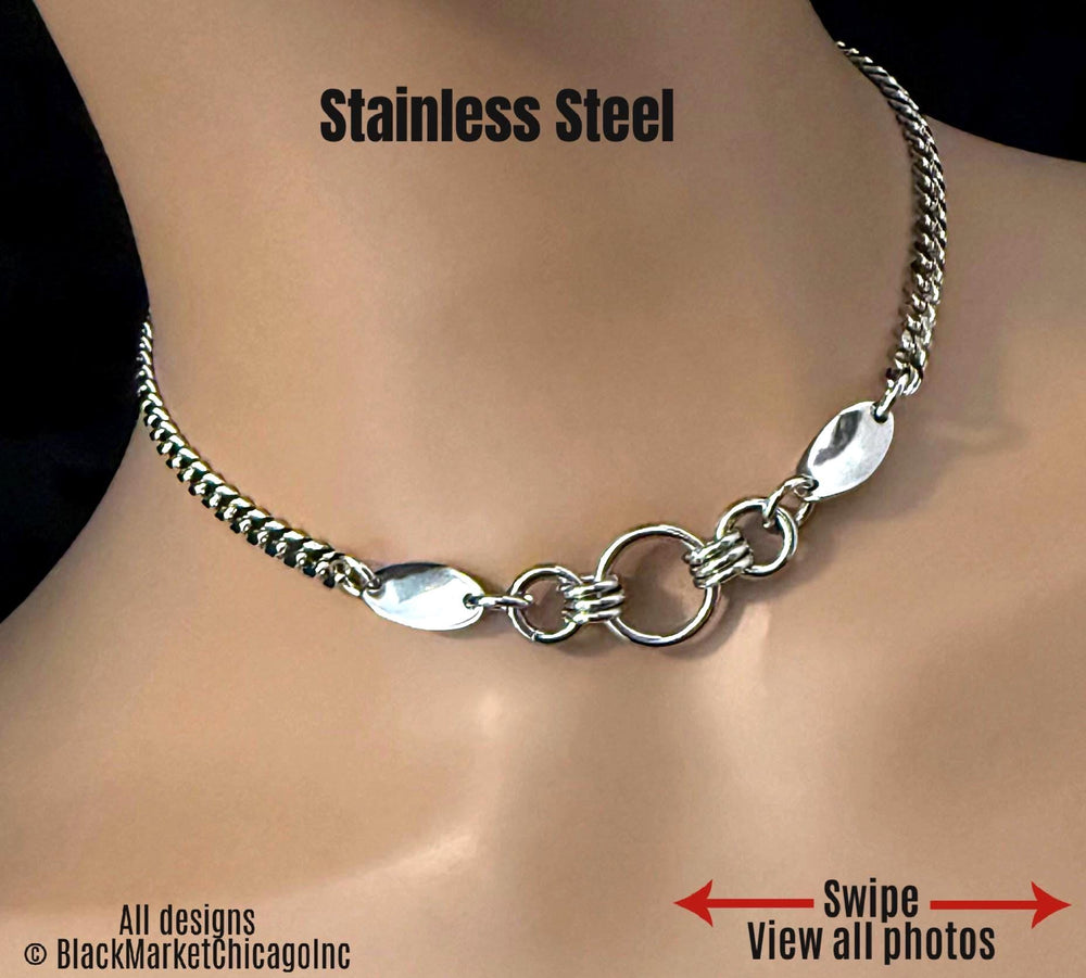 24/7 multi-ring sub day collar; waterproof, discreet; lockable, featuring all stainless steel, 6mm sparkly, sturdy but dainty silver stainless steel curb chain; 18mm center ring bolstered by a thick 10mm ring on either side, each secured by 3 sturdy jump rings, plus ornamental shiny twisted oval ;elegant chic submissive necklace.