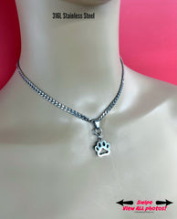 May include: A silver chain necklace with a paw print pendant. The chain is a curb chain style. The text &#39;316L Stainless Steel&#39; is displayed above the necklace.